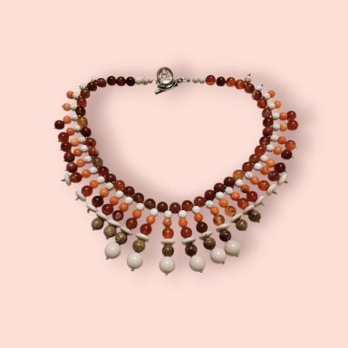 Collar de cuentas en tonos ámbar y blanco con diseño elegante y cierre de gancho.