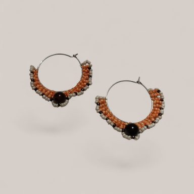 Pendientes de aro con detalles de color naranja y piedra negra en el centro.